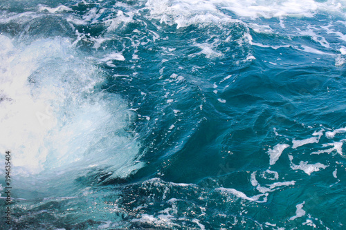 Blue ocean waves with rocks on the beach