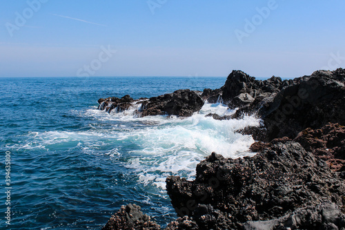 Blue ocean waves with rocks on the beach