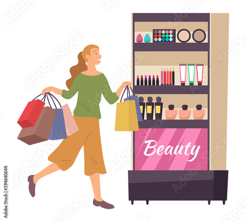 Smiling woman with shopping bags. Young girl picks up multi-colored packages with toiletry. Female character with packages in her hands shopping in a cosmetics store. Person getting ready for makeup