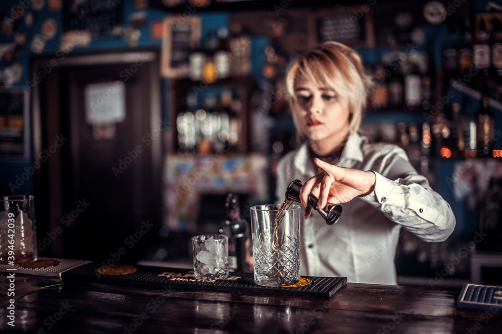 Girl bartender makes a cocktail at the pothouse