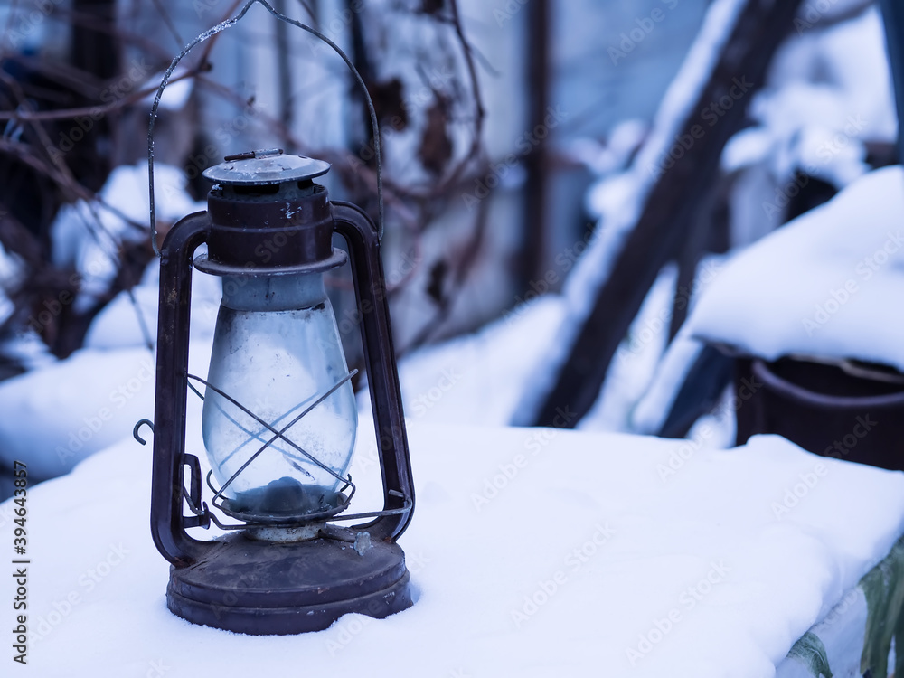 Old kerosene lamp in the snow. 