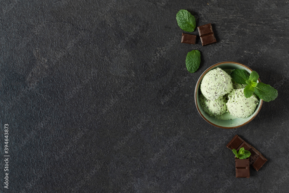 Scoops of mint ice cream with chocolate crumbs in a plate on black background top view. Scoops of mint ice cream with chocolate crumbs in a plate on black background top view.