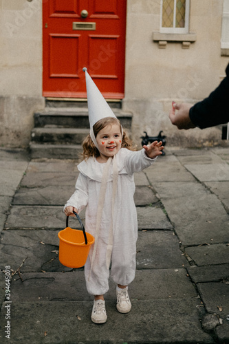 A little girl dressed up and getting sweets while trick or treating