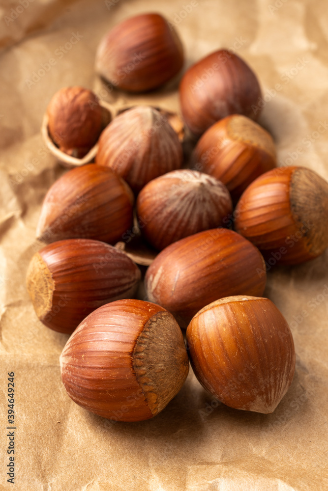 hazelnuts close-up, with selective focus, on brown paper, vertically hazelnuts close-up, with selective focus, on brown paper, vertically