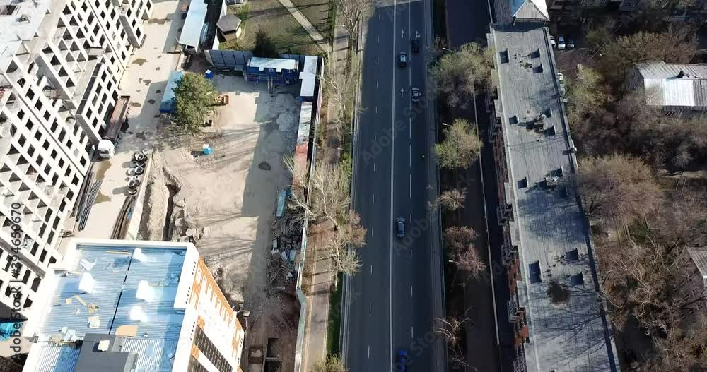 Top view of a road junction in the city of Almaty. The vehicle is waiting for the traffic light signal and is moving in its own direction. Cars, buses, and people move through the intersection. Top view of a road junction in the city of Almaty. The vehicle is waiting for the traffic light signal and is moving in its own direction. Cars, buses, and people move through the intersection.