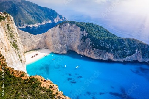 Aerial view to the fluorescent  blue sea of the popular Navagio shipwreck beach on the Greek island of Zakynthos on a summer day with low clouds