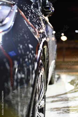 Soft focus car wheel close-up. Gray car in foam. Car wash.