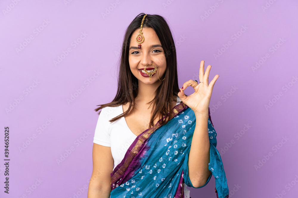 Young Indian woman isolated on purple background showing ok sign with fingers Young Indian woman isolated on purple background showing ok sign with fingers