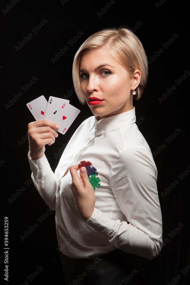 Beautiful blond woman showing a poker cards and gambling chips on black background Beautiful blond woman showing a poker cards and gambling chips on black background