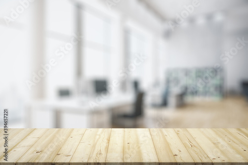 Blank wooden tabletop with bright furnished office on background, mockup © Pixels Hunter