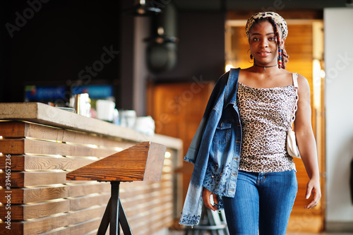 Lovely african american woman with dreadlocks in leopard outfit at cafe. Beautiful cool fashionable black young girl indoor.