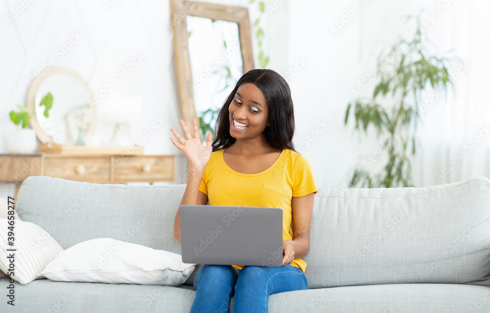 Remote communication concept. Joyful black woman with laptop talking to family, friends or coleagues online from home Remote communication concept. Joyful black woman with laptop talking to family, friends or coleagues online from home