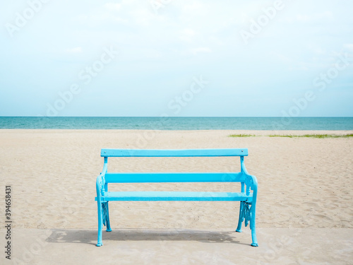 Empty blue wooden bench on the beach.