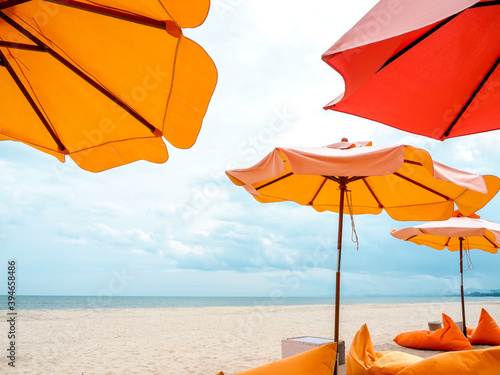 Orange beach umbrellas and bean bag chairs on the beach. photo