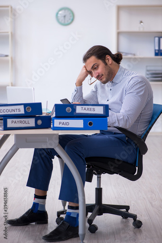 Young male bookkeeper calculating tax payments in the office