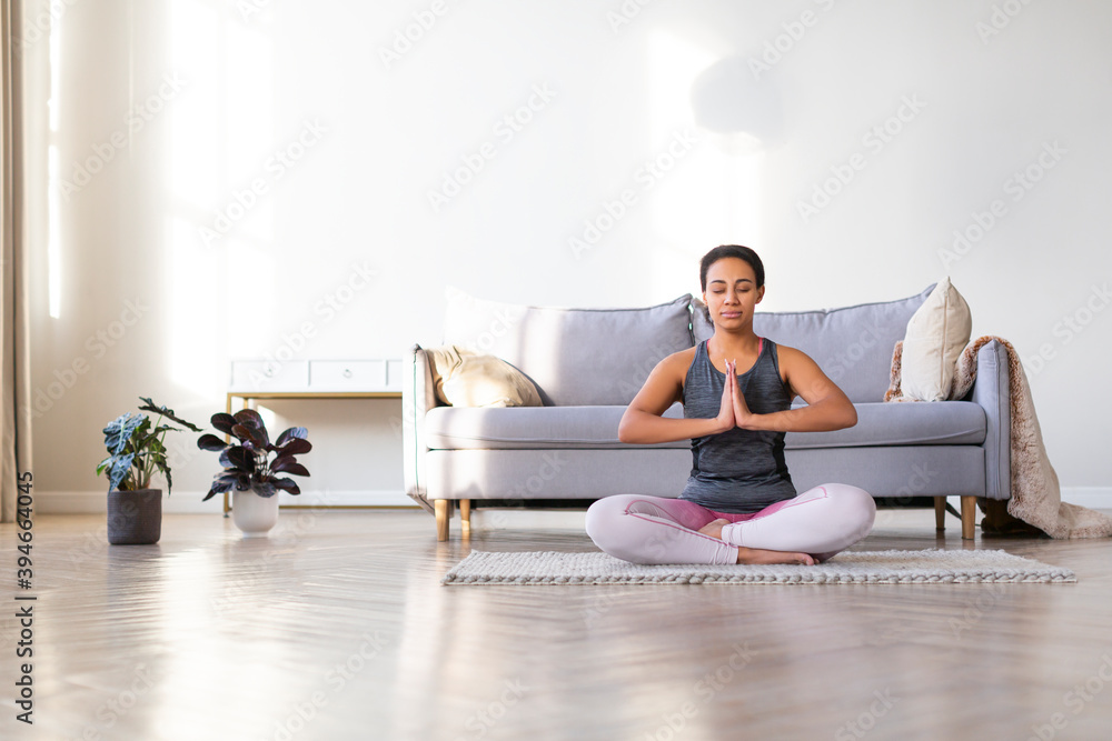 African American woman doing yoga at home. Lotus position.