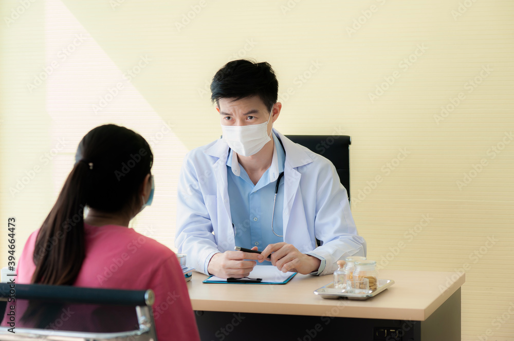 Asian Doctors wearing uniform and mask are taking a history of treating patients with coronavirus or COVID-19 to monitor symptoms and provide advice on how to take care of health after treatment. Asian Doctors wearing uniform and mask are taking a history of treating patients with coronavirus or COVID-19 to monitor symptoms and provide advice on how to take care of health after treatment.
