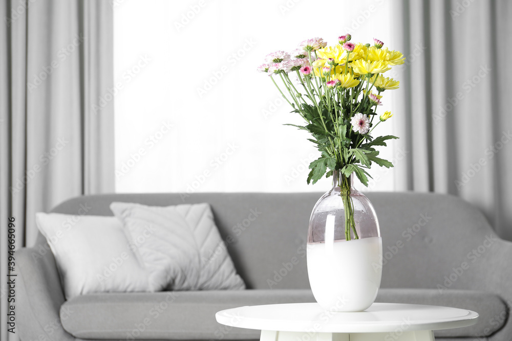 Vase with beautiful flowers on table in living room, space for text. Stylish element of interior design Vase with beautiful flowers on table in living room, space for text. Stylish element of interior design