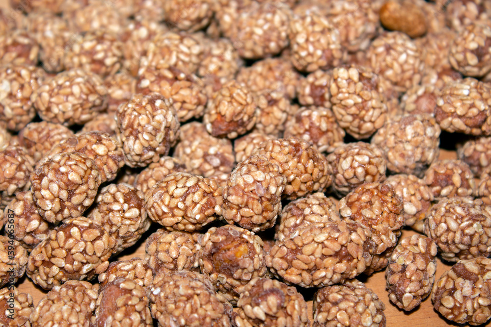 close - up of roasted peanuts with sesame and honey, on wooden background. selective focus close - up of roasted peanuts with sesame and honey, on wooden background. selective focus