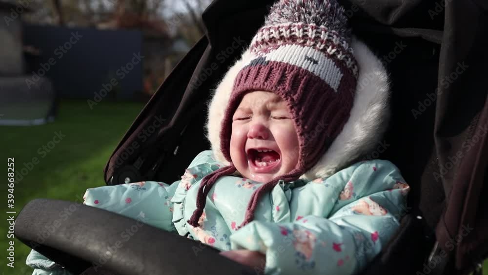Child infant crying in while sitting in a stroller Child infant crying in while sitting in a stroller