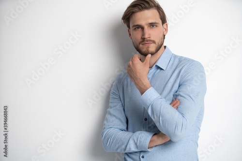 Portrait of a smart young man standing against white background.