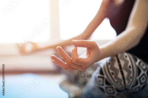 Woman meditating or doing yoga sitting on the mat warm tone