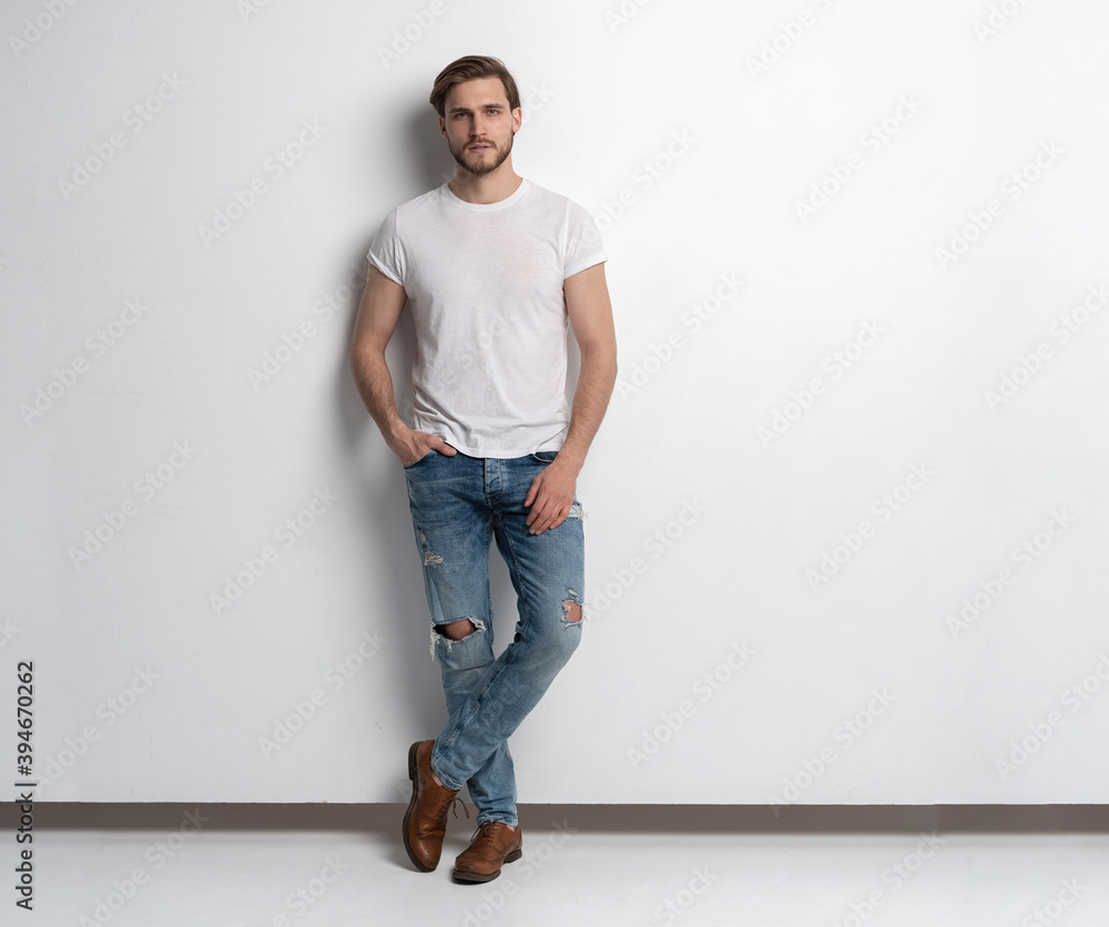 Full length studio portrait of casual young man in jeans and shirt. Isolated on white background. Full length studio portrait of casual young man in jeans and shirt. Isolated on white background.