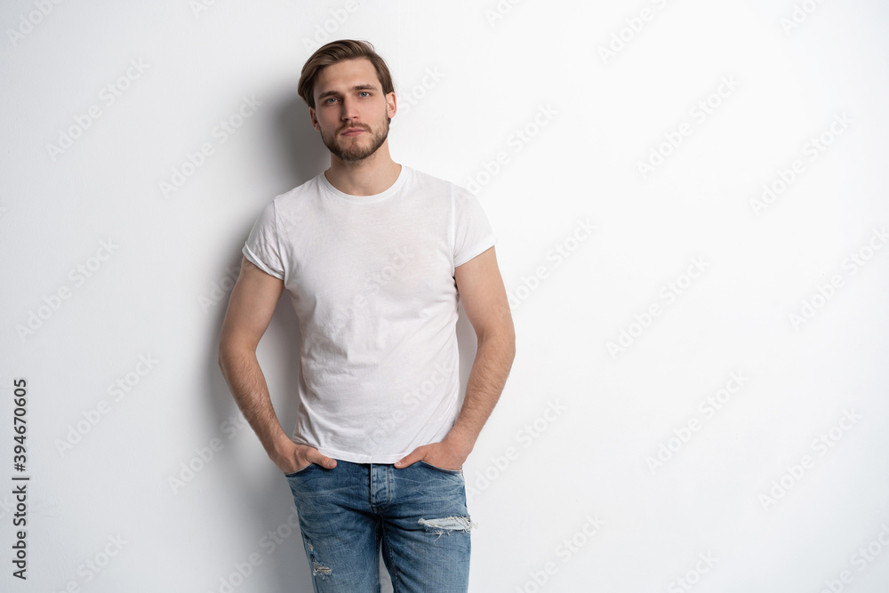 Fototapeta premium Portrait of a smart young man standing against white background.
