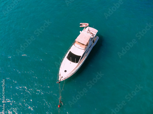 Adorable aerial top view photo of a laxury huge two-storey yach and a small boat next to it sailing across the deep blue sea