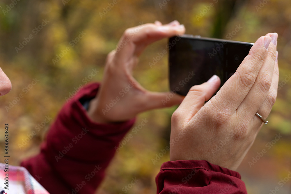 Female hands holding phone outdoor