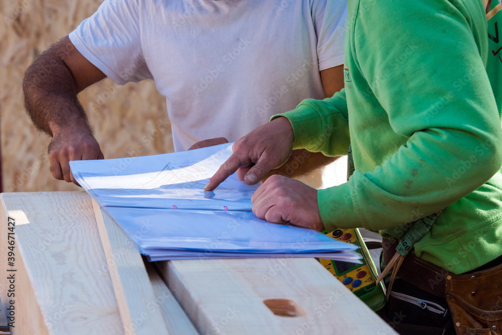 Obraz premium foreman examining construction of a wooden house