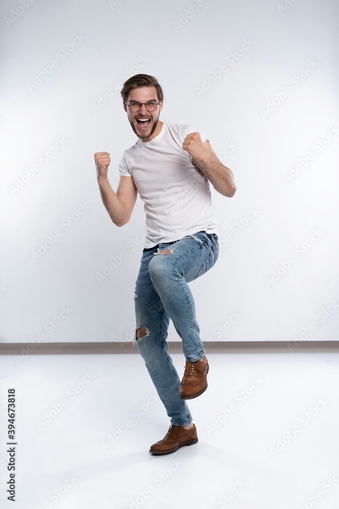 Happy winner. Happy young handsome man gesturing and keeping mouth open while standing against white background. Happy winner. Happy young handsome man gesturing and keeping mouth open while standing against white background.