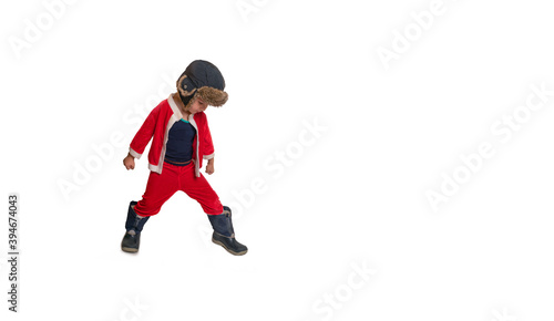 A little boy in a Santa Claus costume stands on a white background
