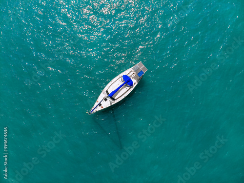 Aerial wonderful view of a enormous white and blue yacht sailing across the blue lagoona © Semachkovsky 