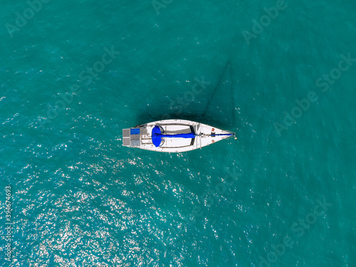 Aerial wonderful view of a enormous white and blue yacht sailing across the blue lagoona