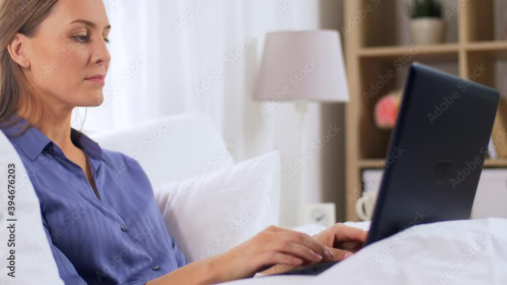 technology, internet and people concept - happy smiling young woman with laptop computer in bed at home bedroom technology, internet and people concept - happy smiling young woman with laptop computer in bed at home bedroom