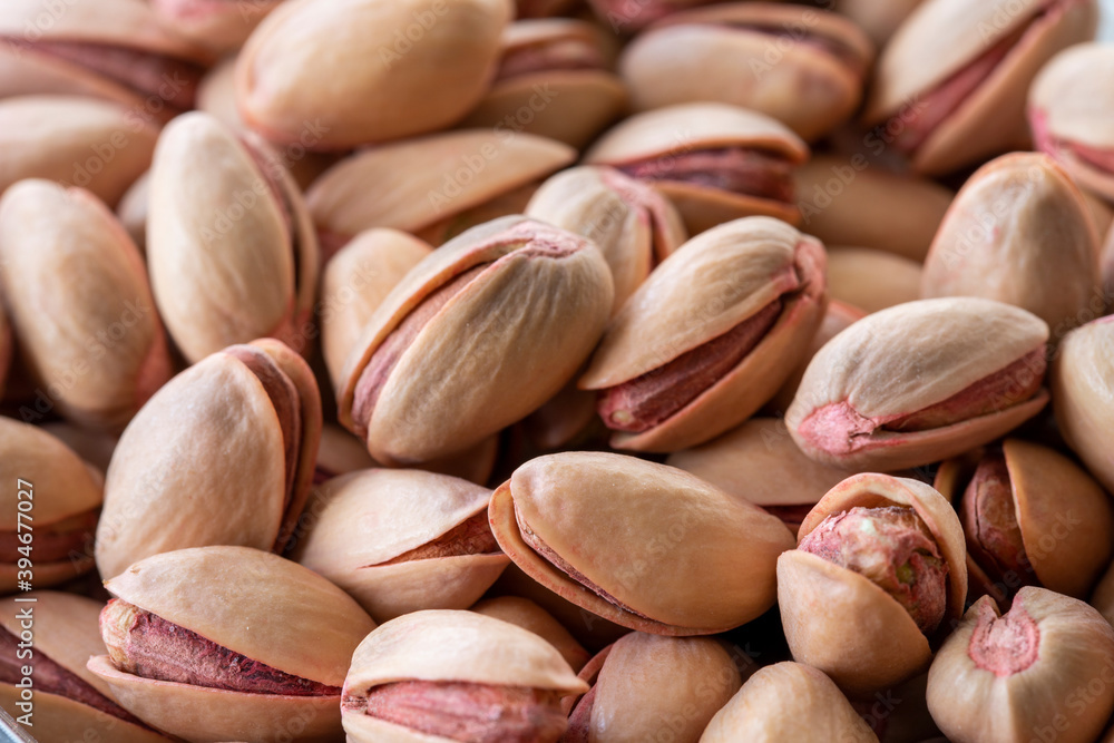 pistachios in bowl - on wooden background - close up