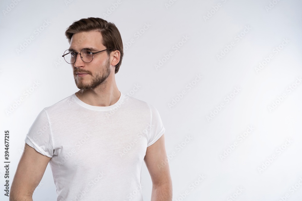 Portrait of a smart young man in glasses standing against white background. Portrait of a smart young man in glasses standing against white background.