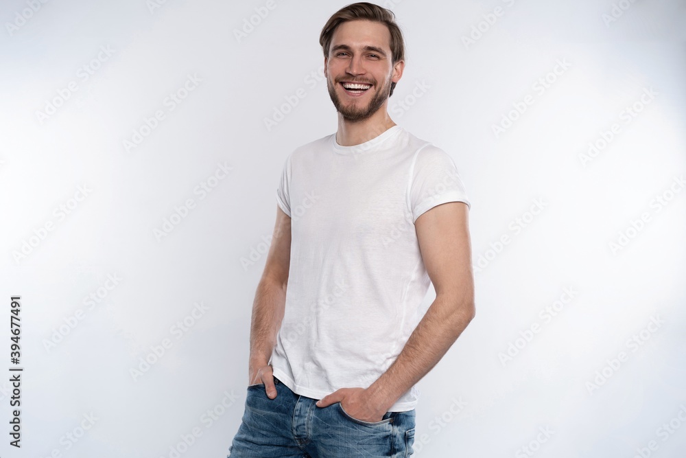 Fototapeta premium Sexy smiling handsome man in white t-shirt isolated on white.