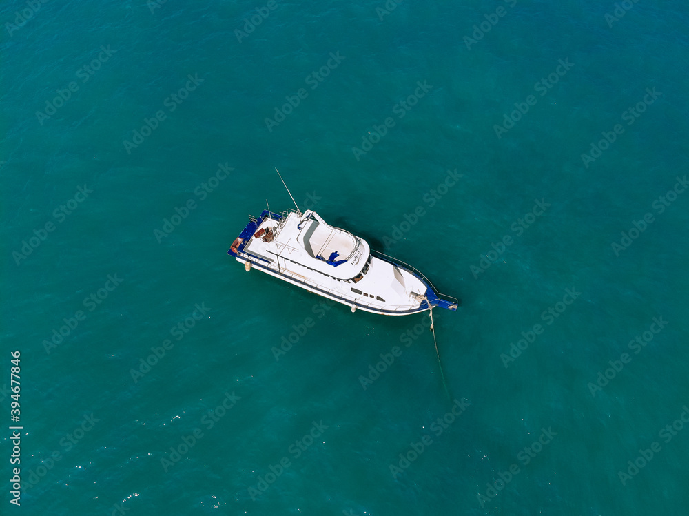 Huge white yacht is sailing alone across the deep blue sea, top view Huge white yacht is sailing alone across the deep blue sea, top view