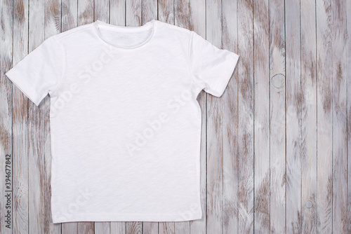 White paint t-shirt with copy space. T-shirt mockup, flat lay. © volurol