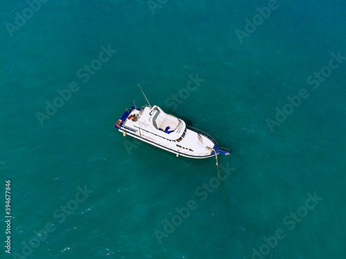 Huge white yacht is sailing alone across the deep blue sea, top view