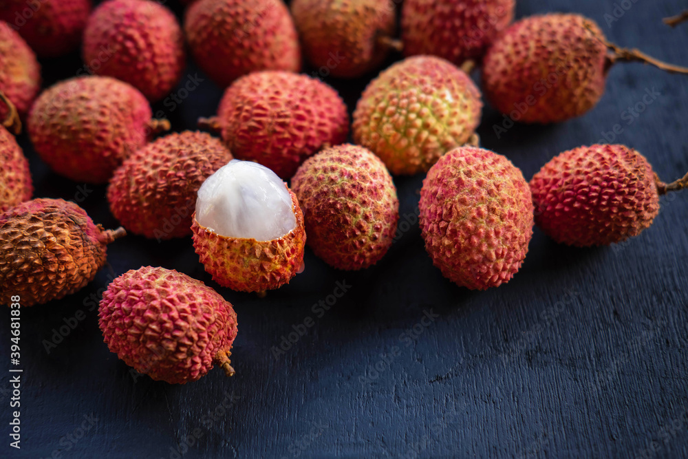 Fresh lychee fruit on a black wooden background Fresh lychee fruit on a black wooden background