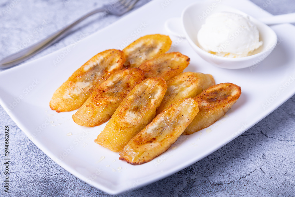 Fried bananas with honey, cinnamon and ice cream. Close-up. Fried bananas with honey, cinnamon and ice cream. Close-up.
