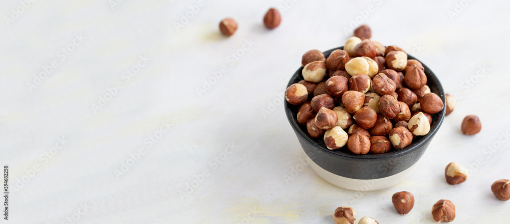 Hazelnuts in plate on white background - copy space Hazelnuts in plate on white background - copy space
