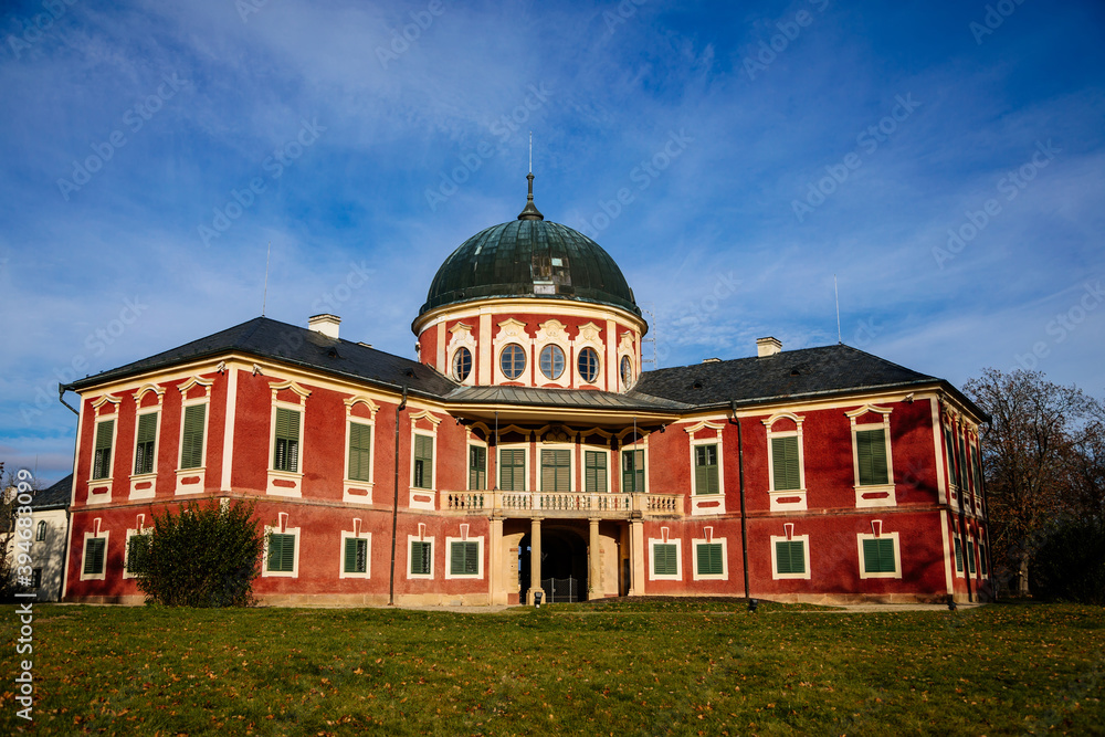 Veltrusy Rococo castle with park and garden, Romantic baroque chateau red with white windows in sunny autumn day, entrance with balcony, Central Bohemia, Czech republic