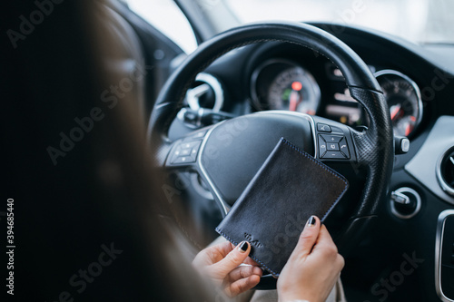 Fotografie Black stylish leather purse for driver's license, passport or id card in woman hands