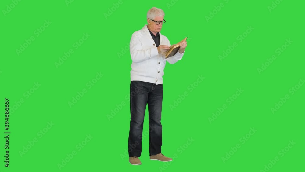 Focused stylish old man reading a book on a Green Screen, Chroma Key. Focused stylish old man reading a book on a Green Screen, Chroma Key.