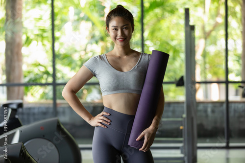 Happy Asian Sporty young woman in sportswear standing cross arm ready to workout and exercise at modern gym,Sport and Recreation Concept © 220 Selfmade studio