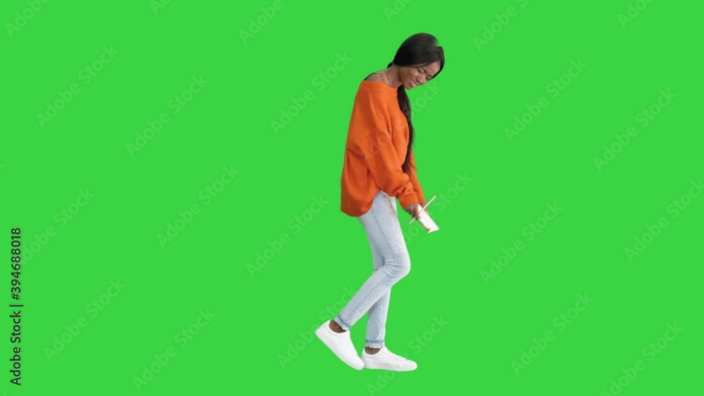 Pretty african american woman in bright jumper reading her notepad and laughing on a Green Screen, Chroma Key. Pretty african american woman in bright jumper reading her notepad and laughing on a Green Screen, Chroma Key.